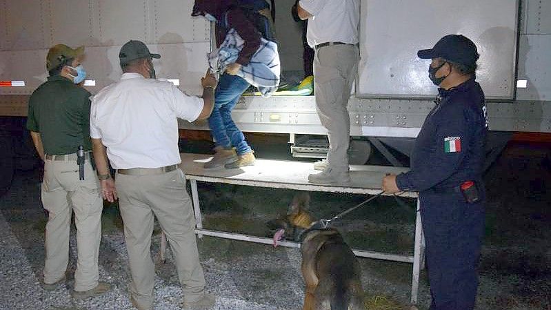 Polizisten und Offiziellle helfen Migranten aus Sattelzügen. Mexikanische Soldaten haben in den Aufliegern dreier Sattelzüge insgesamt 652 mittelamerikanische Migranten in versiegelten Kühlkammern entdeckt. Foto: --/Regierung des Bundesstaates Tamaulipas/dpa