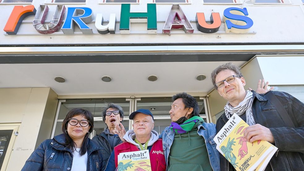 Künstlerliste in der Straßenzeitung: Daniella Fitriab (l-r), Iswanto Hartono (beide vom Künstlerkollektiv ruangrupa), Stefan Marx (Verkäufer der Straßenzeitung „Asphalt“), Reza Afisina (ruangrupa) und Volker Macke (Redaktionschef „Asphalt“) präsentieren vor dem ruruHaus die Oktober-Ausgabe der „Asphalt“ mit der kompletten Künstlerliste der ausstellenden Künstlerinnen und Künstler der «documenta fifteen». Die 15. Weltkunstausstellung findet vom 18.6.-25.9.2022 statt. Foto: Uwe Zucchi/dpa Foto: Uwe Zucchi