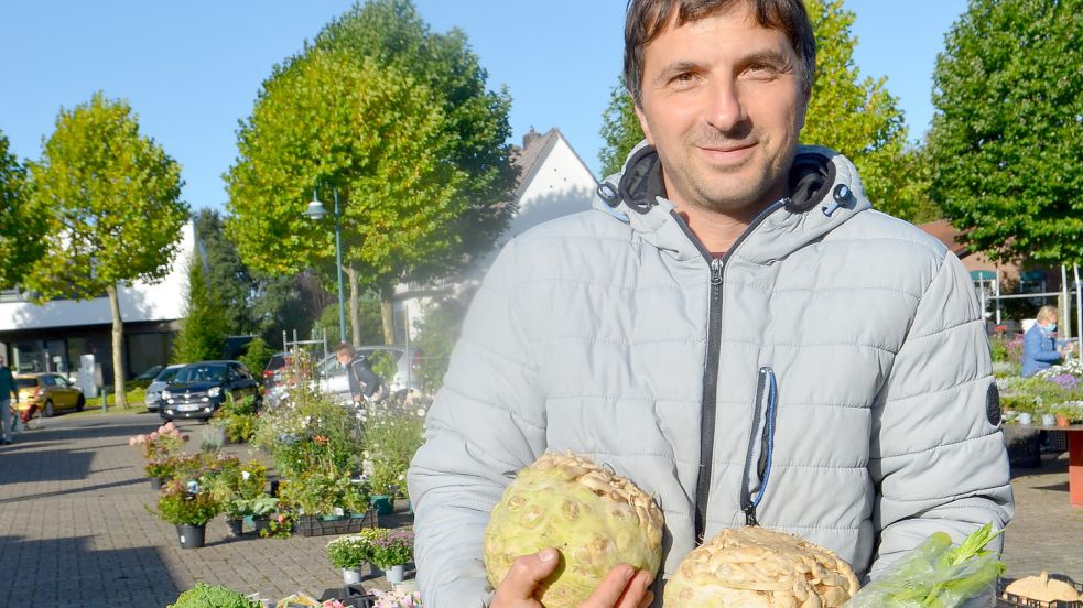 Etem Demirhan präsentiert den Knollen- und den Staudensellerie, den er auf dem Rhauderfehner Wochenmarkt am Marktstand seines Bruders Bilgin derzeit verkauft. Foto: Fertig