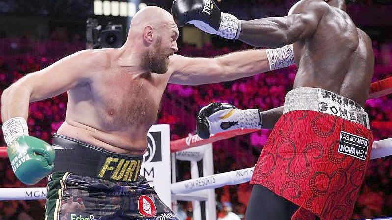 Tyson Fury (l) trifft Deontay Wilder mit seiner Linken. Foto: Chase Stevens/FR171365 AP/dpa