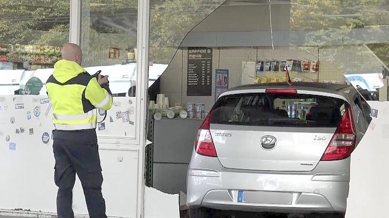 Fassade durchbrochen: Das Auto, gesteuert von einem kleinen Jungen, steht in einer Tankstelle in Bochum. Foto: Markus Gayk/dpa