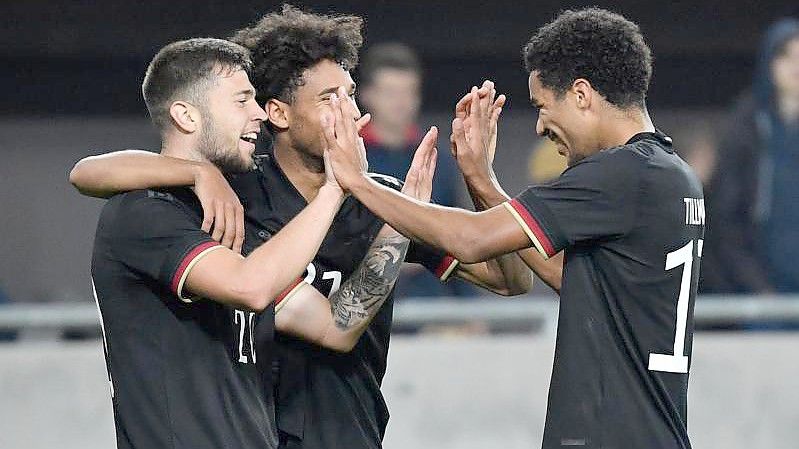 Erik Shuranov (l-r) bejubelt sein Tor zum 3:1 für Deutschland gegen Ungarn mit Kevin Schade und Malik Tillman. Foto: Marton Monus/dpa