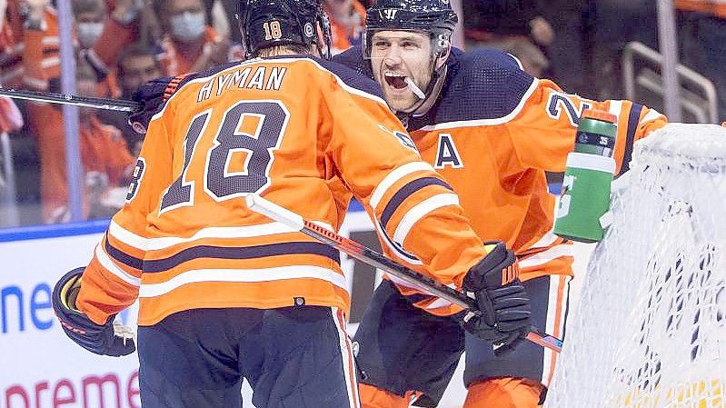 Leon Draisaitl (r) feiert mit Teamkollege Zach Hyman den Sieg der Edmonton Oilers. Foto: Jason Franson/The Canadian Press/AP/dpa