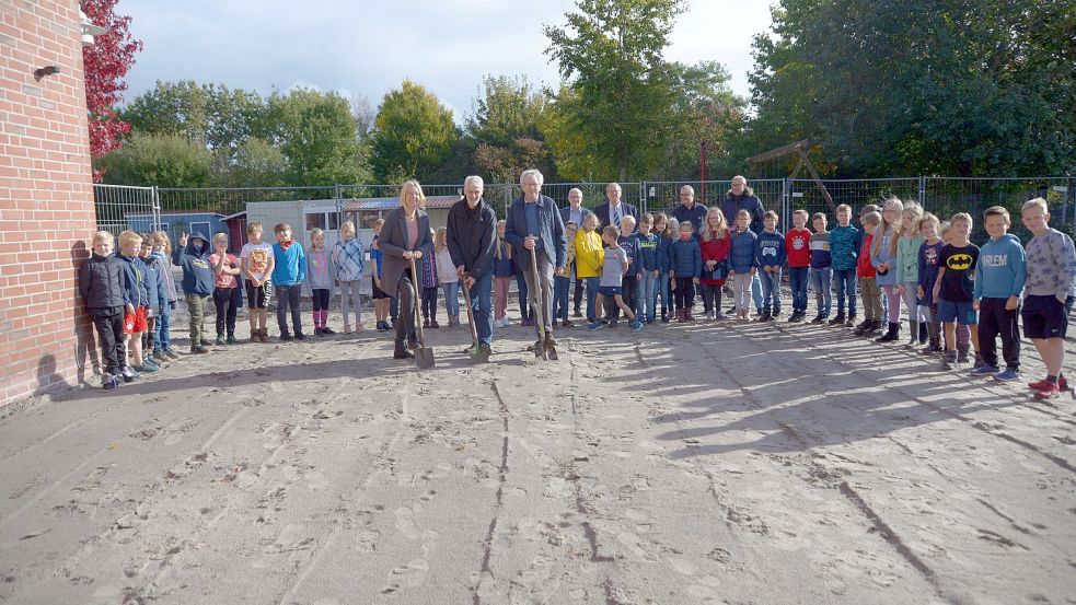 Zwei Klassen der Primarstufe waren dabei, als Susanne Ziegler (stellvertretende Leiterin), Kurt Plagge vom Vorstand des Trägervereins und Architekt Georg Tjards zum Spaten griffen. Foto: Lüppen