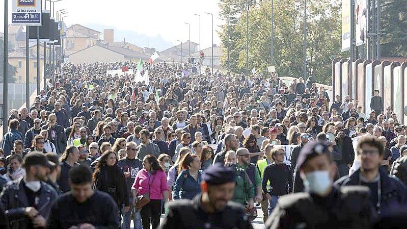 Protestteilnehmer sind in Bologna mit Fahnen auf der Straße, um gegen den sogenannten „Grünen Pass“ zu demonstrieren. Foto: Michele Nucci/LaPresse/AP/dpa