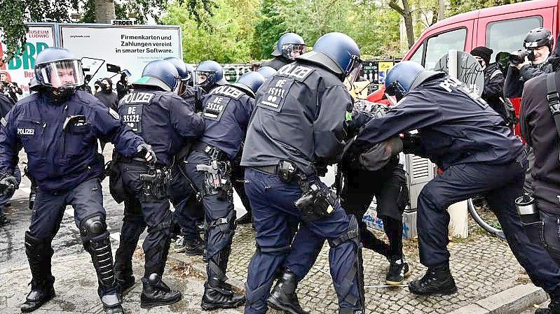 Polizisten nehmen einen Demonstranten am Rande der Räumungsaktion in Berlin-Mitte fest. Foto: Fabian Sommer/dpa
