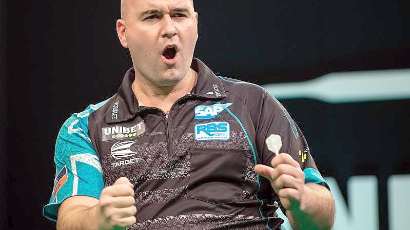 Der Engländer Rob Cross bezwang im EM-Finale den Niederländer Michael van Gerwen mit 11:8. Foto: Swen Pförtner/dpa