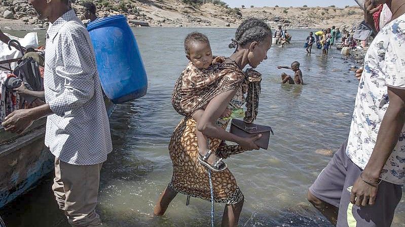 Flüchtlinge aus der Region Tigray kommen am Ufer des Tekeze-Setit im Sudan an. (Archivbild). Foto: Nariman El-Mofty/AP/dpa