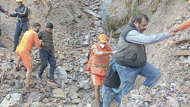 Mitarbeiter der nationalen Katastrophenschutztruppe in Indien bei der Rettung von Zivilisten, die nach schweren Regenfällen im Dorf Chhara gestrandet sind. Foto: Uncredited/NDRF/AP/dpa