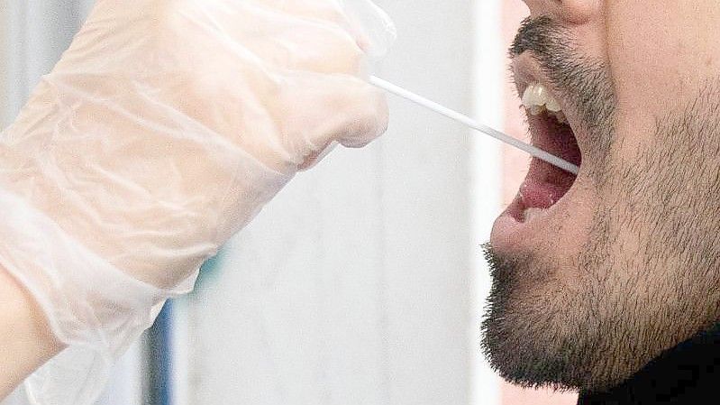 Ein Patient lässt vor einer Arztpraxis einen Abstrich für einen PCR Corona-Test machen. (Archivbild). Foto: Kay Nietfeld/dpa