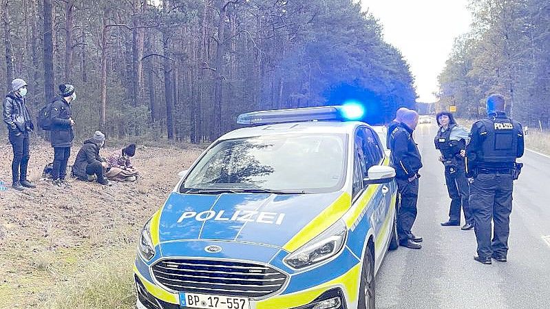 Bundespolizisten stehen neben einer Gruppe von Migranten, die zuvor über die deutsch-polnische Grenze gegangen waren. Foto: Danilo Dittrich/dpa-Zentralbild/dpa