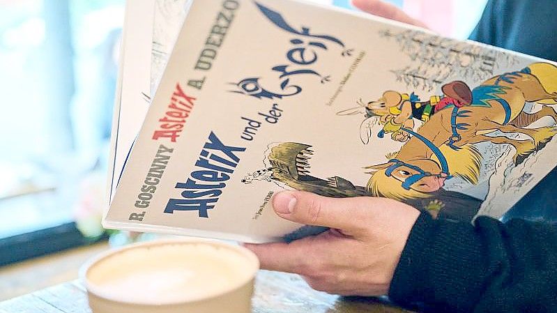 Ein Mann schaut in den neuen Asterix-Band "Asterix und der Greif". Foto: Annette Riedl/dpa