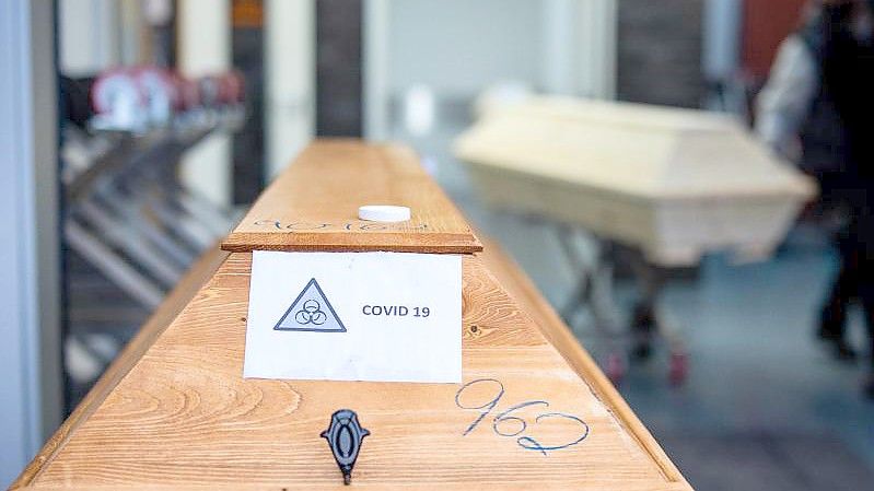 Todesursache Coronavirus: Ein Sarg mit einem Verstorbenen mit der Aufschrift „Covid 19“. Foto: Rolf Vennenbernd/dpa
