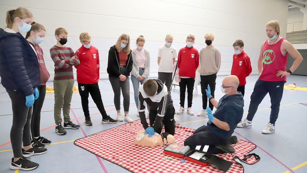 An einer Puppe übten die Kinder und Jugendlichen unter Leitung von Knud Linnert (l.) die Wiederbelebung. Organisator Michael Bohnen (stehend) schaute zu. Foto: Passmann