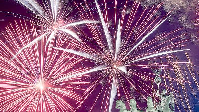 Ein Feuerwerk während Deutschlands größter Silvesterparty hinter dem Brandenburger Tor. Foto: Ralf Hirschberger/dpa