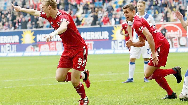 Kiels Finn Porath (l) und Darmstadts Fabian Holland kämpfen um den Ball. Foto: Axel Heimken/dpa