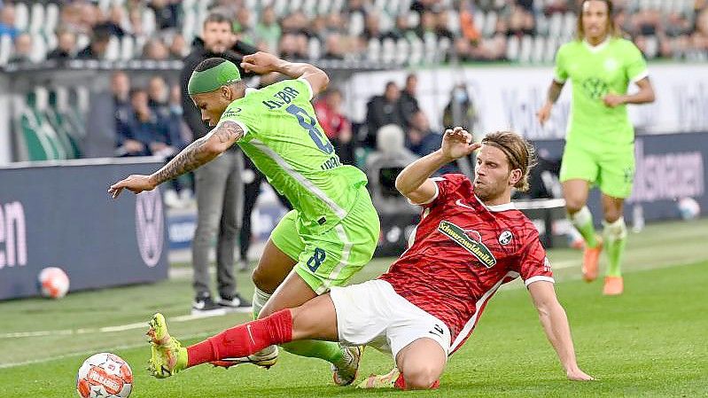 Wolfsburgs Aster Vranckx (l) spielt gegen Freiburgs Lucas Höler. Foto: Swen Pförtner/dpa