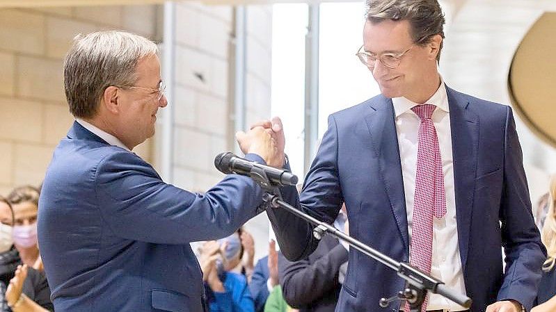 Armin Laschet (l,), Ministerpräsident von Nordrhein-Westfalen, gratuliert Landesverkehrsminister Hendrik Wüst (beide CDU) zur Nominierung als Regierungs- und Landesparteichef. Foto: Marcel Kusch/dpa