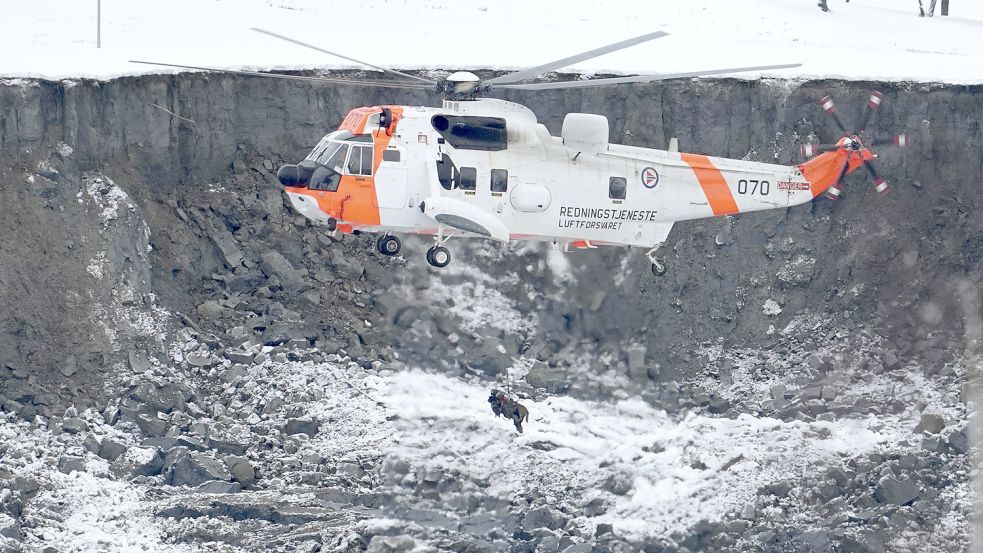 Ein Rettungshubschrauber lässt einen Suchhund in ein Loch hinab, das durch einen Erdrutsch entstanden ist. Wenn Menschen abseits von Naturkatastrophen vermisst werden, können in der Regel auch Suchhunde nicht helfen. Foto: Hagen/NTB/AP/dpa