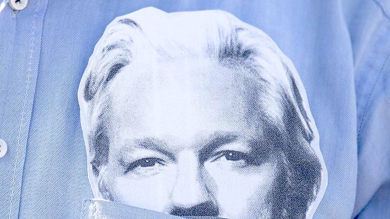 Ein Demonstrationsteilnehmer mit einer Maske des Wikileaks-Gründers Julian Assange im Hemd (Archivbild). Foto: Fabian Sommer/dpa/Archiv