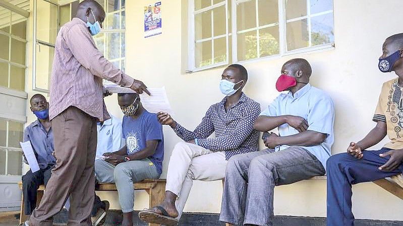 Menschen in Gulu in Uganda warten darauf, im Aywee-Gesundheitszentrum gegen das Coronavirus geimpft zu werden. (Archivbild). Foto: Nicholas Bamulanzeki/AP/dpa