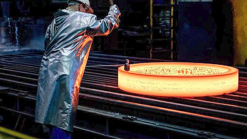 Ein glühender Rohling wird im ThyssenKrupp Werk Rothe gestempelt. Foto: Marcel Kusch/dpa