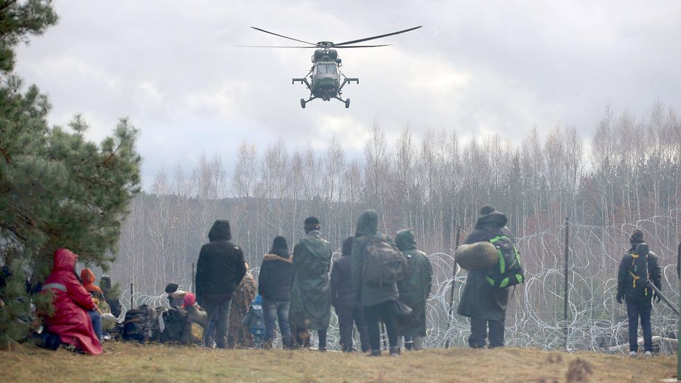 Wie weit eskaliert die Lage noch? Ein polnischer Militärhubschrauber fliegt über eine Gruppe Migranten, die sich an der weißrussisch-polnischen Grenze versammelt haben. Mehrere Hundert Migranten haben sich nach Angaben der Behörden in Belarus zu Fuß auf den Weg zur Grenze zum EU-Nachbarland Polen gemacht. Foto: Leonid Shcheglov/picture alliance/dpa/BelTA/AP
