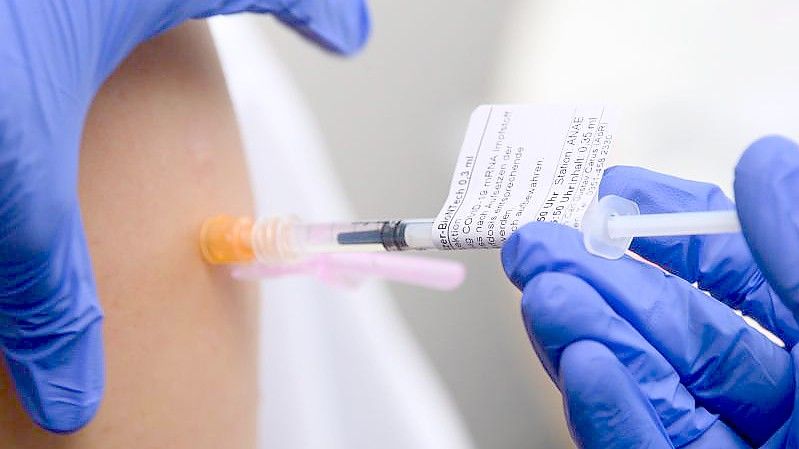 Eine Ärztin impft im Universitätsklinikum in Dresden einen Arztkollegen mit der dritten Impfung gegen das Coronavirus. Foto: Robert Michael/dpa-Zentralbild/dpa