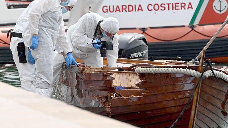 Italienische Forensiker begutachten den Schaden an einem Boot. Ein Motorboot, besetzt mit zwei Deutschen, hatte das kleine Boot eines italienischen Paares gerammt. (Archivbild). Foto: Gabriele Strada/AP/dpa