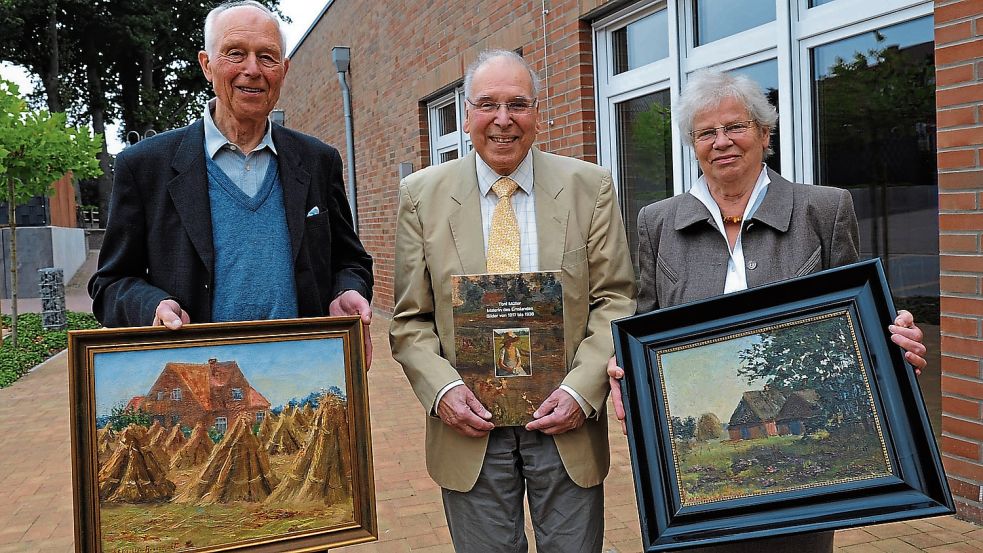 Die Zeitzeugen (von links) Bernhard Ahrens mit dem Gemälde „Frackeler Altenteil am Kornfeld“, Großneffe der Malerin und Buchautor Volkmar Lent sowie Elisabeth Schlichter mit dem Gemälde „Heide bei den Kathener Schafställen“. Foto: Kroehnert