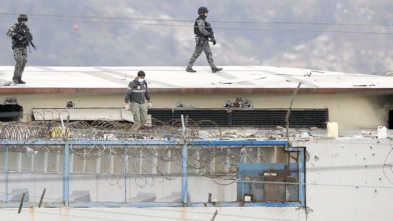 Polizisten auf dem Gefängnisdach: Bei erneuten gewalttätigen Auseinandersetzungen in einem Gefängnis in Ecuador sind Medien zufolge mindestens 58 Häftlinge ums Leben gekommen. Foto: Jose Sanchez/AP/dpa