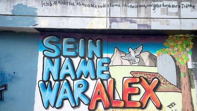 Auf einer Mauer ist ein Graffiti "Sein Name war Alex" für getöteten Tankstellen-Mitarbeiter gesprüht. Foto: Oliver Dietze/dpa