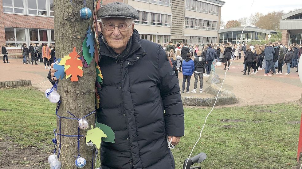 Das Foto zeigt Albrecht Weinberg mit dem Baum, den er der Rhauderfehner Schule geschenkt hat. Foto: Fäustel