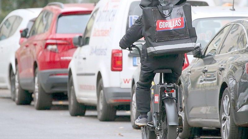 Ein Mitarbeiter des Lebensmittel-Lieferdienstes Gorillas fährt durch die Straßen der Hauptstadt. Foto: Wolfgang Kumm/dpa