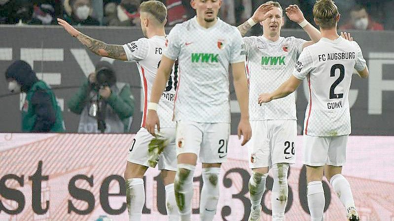 Augsburgs Mittelfeldspieler André Hahn (2.v.r) freut sich mit seinen Mannschaftskameraden nach seinem Treffer zum 2:0. Foto: Matthias Balk/dpa