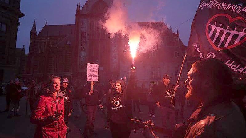 Menschen bei einer Demonstration gegen die Covid-19-Beschränkungen in Amsterdam teil. Nach den heftigen Ausschreitungen in Rotterdam haben Randalierer in verschiedenen Städten der Niederlande für Unruhen gesorgt. Foto: Peter Dejong/AP/dpa