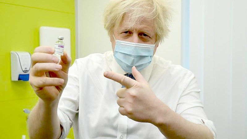 Boris Johnson, Premierminister von Großbritannien, hält ein Fläschchen mit Impfstoff von Astrazeneca während seines Besuchs in dem Corona-Impfzentrum des Zentrums für Gesundheit und Wohlbefinden in Orpington. Foto: Jeremy Selwyn/Evening Standard/PA Wire/dpa