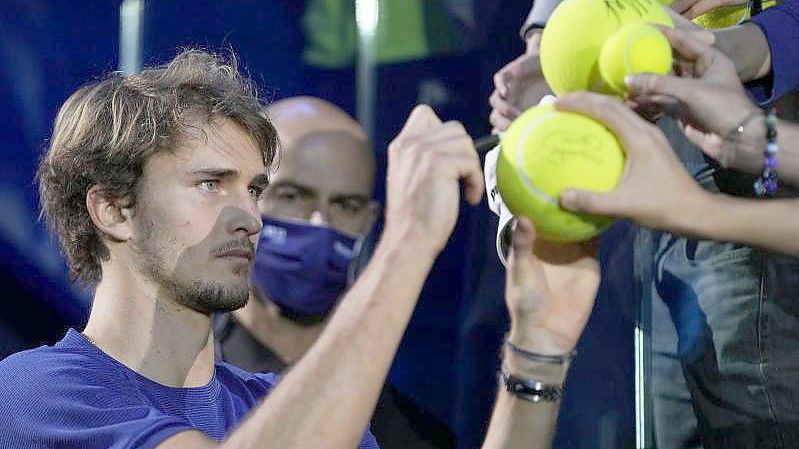 Alexander Zverev (l) gibt nach der ATP-Siegerehrung Autogramme. Foto: Luca Bruno/AP/dpa