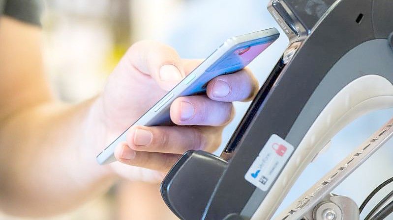 Ein Smartphone wird an ein Kassenterminal gehalten. Mit der entsprechenden App kann man so bezahlen.). Foto: Franziska Gabbert/dpa-tmn/dpa