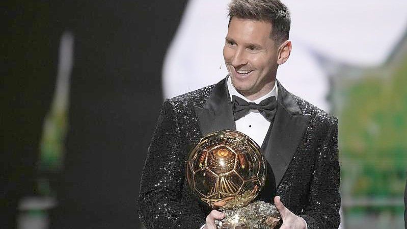 Lionel Messi von Paris Saint-Germain mit seiner Ballon d'Or-Trophäe 2021. Der Fußballer erhält den Goldenen Ball bereits zum siebten Mal in seiner Karriere. Foto: Christophe Ena/AP/dpa