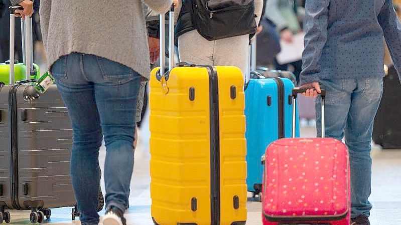 Fluggäste schieben ihre Rollkoffer durch den Abflugbereich im Terminal 1 des Flughafens BER. Foto: Monika Skolimowska/dpa-Zentralbild/dpa