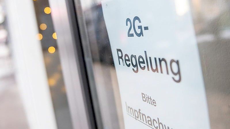 Ein Schild weist auf die „2G-Regelung“ hin. Sie gilt für alle Geschäften - außer für solche des täglichen Bedarfs. Foto: Daniel Bockwoldt/dpa