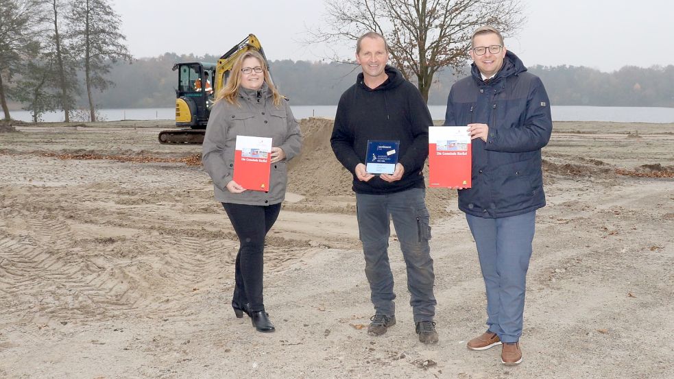 Anke Rönneper, Kämmerin der Gemeinde Barßel, und deren Bürgermeister Nils Anhuth (rechts) überbrachten Hans-Jürgen Lampe den bewilligten Förderbescheid für den Wohnmobilstellplatz in Harkebrügge. Foto: Wlodarczyk/Gemeinde Barßel