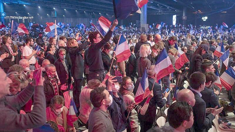 Anhänger des rechtsextremen französischen Präsidentschaftskandidaten Éric Zemmour schwenken Plakate und französische Flaggen. Foto: Rafael Yaghobzadeh/AP/dpa