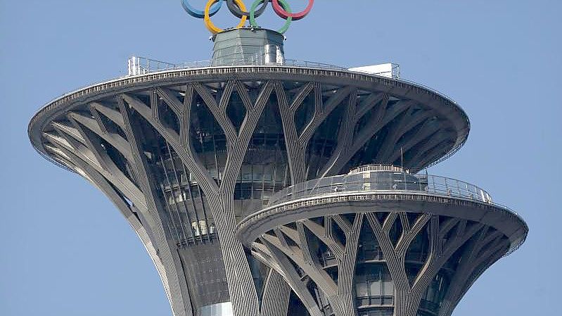 Die olympischen Ringe sind auf der Spitze des Olympiaturms in Peking zu sehen. Foto: Mark Schiefelbein/AP/dpa