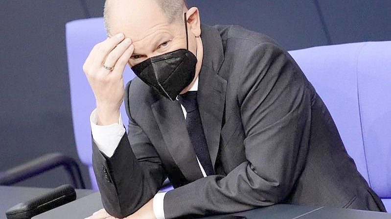 Olaf Scholz (SPD), designierter Bundeskanzler, fasst sich an den Kopf während der Sitzung im Bundestag. Foto: Kay Nietfeld/dpa