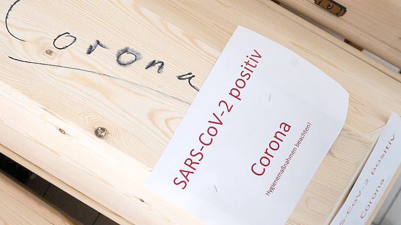 Särge mit Aufschrift „Corona“ und „SARS-CoV-2 positiv - Corona“ mit Verstorbenen in einem Krematorium in Giesen. Foto: Julian Stratenschulte/dpa