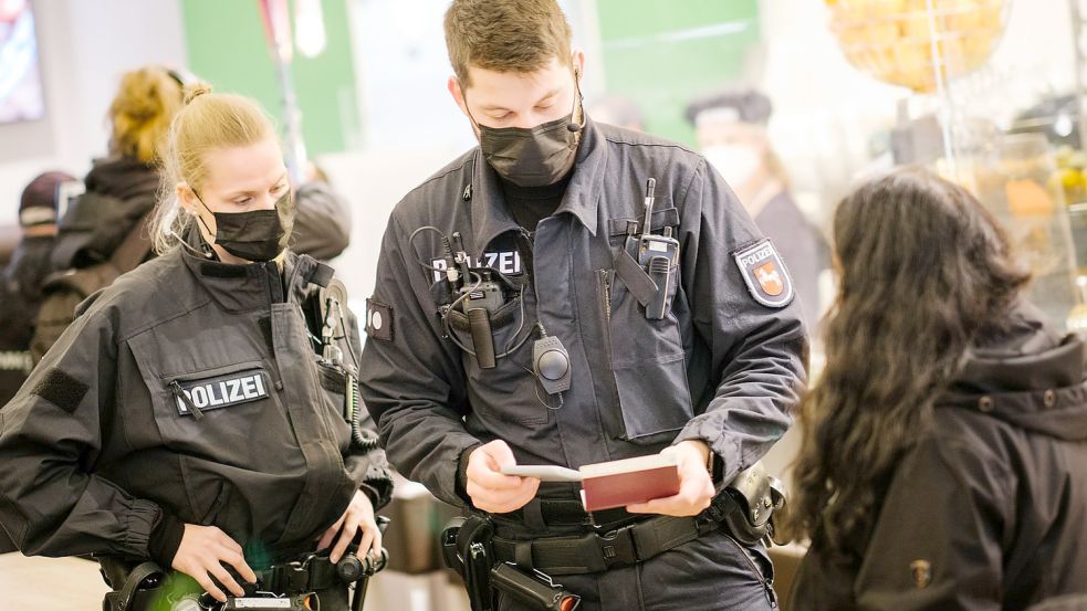 Beamte der niedersächsischen Bereitschaftspolizei prüfen die Impfnachweise von Restaurantgästen während einer Corona-Kontrolle. Dürften sie selbst dabei ungeimpft sein? (Symbolfoto aus Hannover) Foto: Ole Spata/dpa