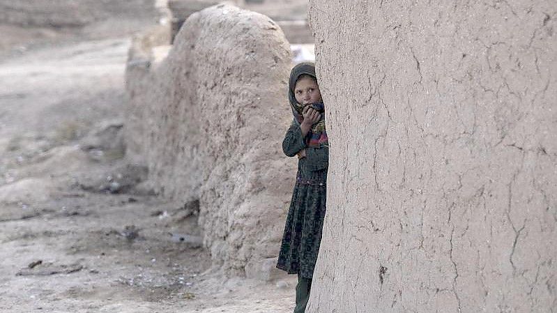 Ein Mädchen schaut aus ihrem Haus im afghanischen Dorf Kamar Kalagh. Foto: Petros Giannakouris/AP/dpa