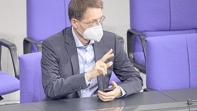 Karl Lauterbach (SPD), Bundesminister für Gesundheit, wartet auf den Beginn einer Debatte im Bundestag. Foto: Michael Kappeler/dpa